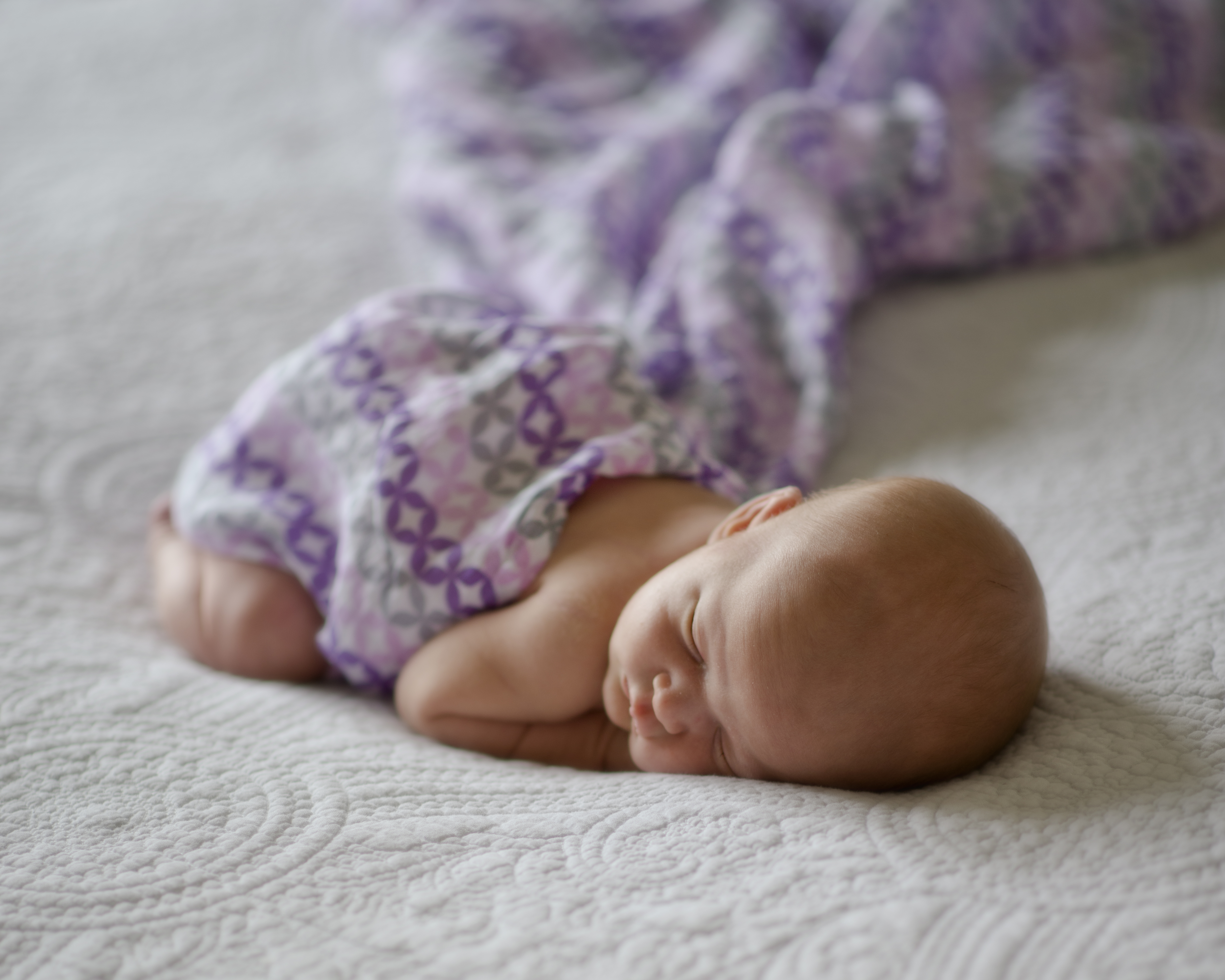 Baby sleeping during newborn session wrapped in a swaddle