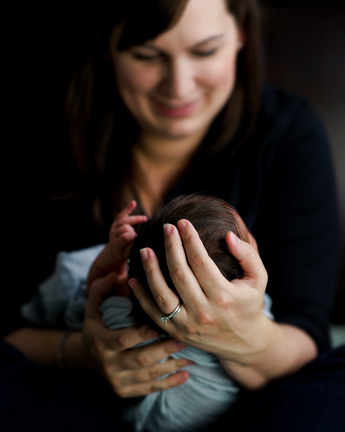 Mother holds newborn son. Lifestyle Newborn Photography in Fairfax, VA by Erin Tetterton Photography